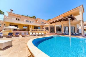 a swimming pool in front of a house at Villa Juan Carlos in Cala Vinyes
