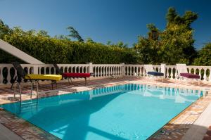 una piscina con sillas y una valla blanca en Prestige Property - Da Costa en Río de Janeiro