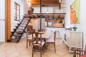 a room with a table and chairs and a spiral staircase at Sa Fusteria in Sóller