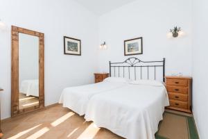 biała sypialnia z łóżkiem i lustrem w obiekcie Son March w mieście Petra +33 zdjęcia