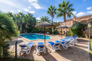 a group of chairs and umbrellas next to a swimming pool at Can Lopez Vara in Campos