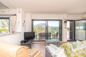 ein Wohnzimmer mit einem Sofa und einem TV in der Unterkunft Casa Fiorella in San Pantaleo
