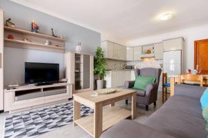 a living room with a couch and a tv and a table at Apartamento Los Morales in Puerto del Carmen