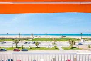 - une vue sur un parking avec des palmiers et la plage dans l'établissement Las Vistas del Último Paraíso, à Conil de la Frontera