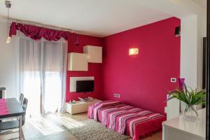 een rode slaapkamer met een bed en een bureau bij Casa Vacanze Porto Torres in Porto Torres