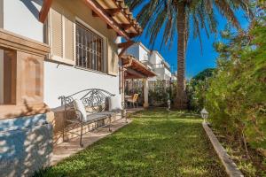 a backyard with a bench and a palm tree at Rosmare in Port d'Alcudia