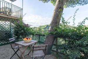 a table and chair next to a tree with a bowl of fruit at Simona in Fetovaia