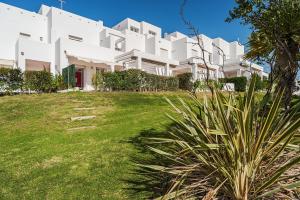 コニル・デ・ラ・フロンテーラにあるDúplex tejar D piscinas y familiasの庭付白い建物のイメージ