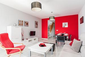 コニル・デ・ラ・フロンテーラにあるDúplex 2 habitaciones, piscina Solo mayores de 30の赤いアクセントの壁のリビングルーム
