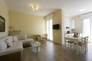 uma sala de estar com um sofá, uma mesa e uma cozinha em Elegante appartamento al centro storico em Torri del Benaco