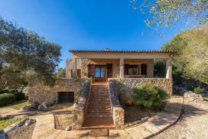 uma casa de pedra com escadas que levam a uma casa em Es Pinaró Sansó em Artà