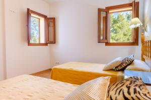 a room with two beds and two windows at Can Ramon 1 in Sant Josep de Sa Talaia +24 photos