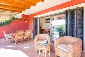 patio con sedie in vimini e tavolo. di Residenza Fiorella a San Pantaleo