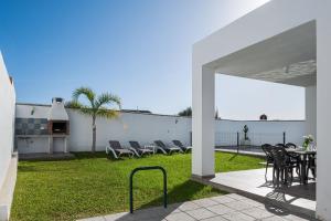 コニル・デ・ラ・フロンテーラにあるVilla Conilsur 2のパティオ(芝生の上にテーブルと椅子付)