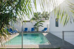 una piscina con sedie blu accanto a un edificio di Villa Sultan 12 a Conil de la Frontera