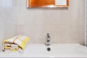 a bathroom with a sink with a towel on it at Las tres hermanas in Conil de la Frontera