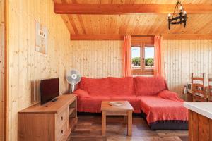 a living room with a red couch and a tv at Las tres hermanas in Conil de la Frontera