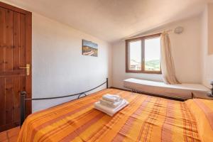 a bedroom with a large bed and a window at Accu is Prezzus D fronte mare in Villasimius