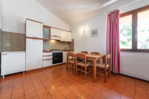 ヴィッラシミーウスにあるAccu is Prezzus Villetta E2 50mtのキッチン(木製テーブル、テーブル、椅子付)