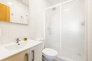 een witte badkamer met een toilet en een wastafel bij Apartamento La Higuera 1 in Conil de la Frontera