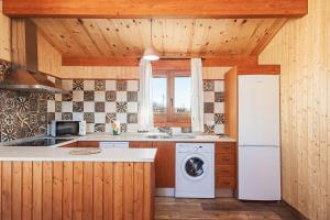 a kitchen with a white refrigerator and a sink at Las tres hermanas in Conil de la Frontera