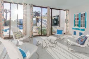 a living room with white chairs and a pool at Casa Margarita in Las Breñas