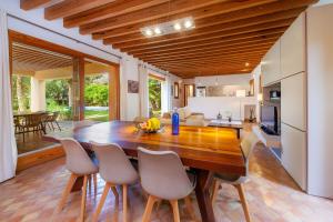 una cucina e una sala da pranzo con tavolo e sedie in legno di Villa Cala Bona a Cala Bona