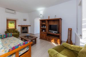 a living room with a couch and a tv at Sa Casona in Portocolom