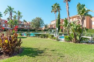 a park with palm trees and a swimming pool at Jardin del Golf in Chiclana de la Frontera
