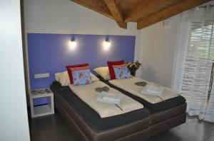 twee bedden in een slaapkamer met een blauwe muur bij Haus Piesendorf in Piesendorf
