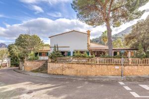 a house with a fence and a tree at Villa Gran Voramar in Cala de Sant Vicent