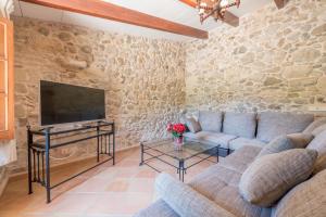 a living room with a couch and a tv at S'era de Son Roig in Sant Joan