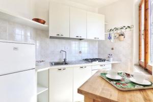 uma cozinha com armários brancos e uma mesa de madeira em Appartamento Innamorata 2 em Palazzo