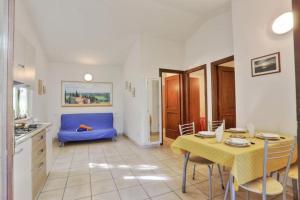 a kitchen and living room with a table and a blue couch at Appartamenti Le Querce - Lentisco in Capoliveri