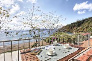 a table on a balcony with a view of the beach at Appartamento Innamorata 2 in Palazzo
