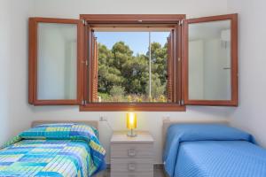ブドーニにあるNuova Villetta a soli 200 mt dalla spiaggiaのベッド2台と窓のある寝室