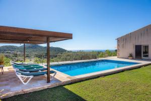 een zwembad met ligstoelen en een huis bij Finca Bionic in Artá
