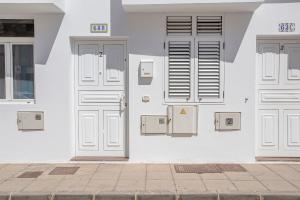 un edificio blanco con puertas blancas y cajas eléctricas en Casa Bonita Argana en Arrecife