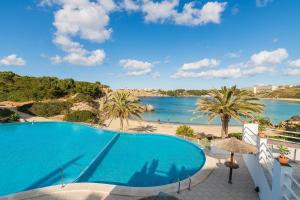 a swimming pool with a view of the beach at White Sands 3.07 in Arenal d'en Castell