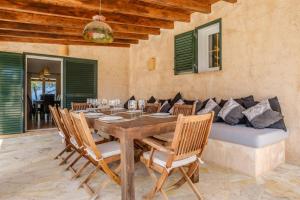a dining room with a table and chairs and a couch at Can Moustique in Sant Josep de sa Talaia