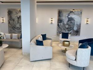 a lobby with couches and chairs and paintings at Berks Luxury Serviced Apartments , free parking, free Gym and free wifi in Bracknell