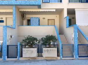 una casa con colonne blu e alberi di fronte ad essa di Casa Vacanze Marzia a Otranto a Otranto