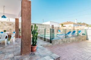 a patio with a table and chairs and a swimming pool at Chalet Rubio Cabeza in Conil de la Frontera