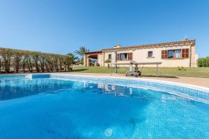 Una gran piscina azul frente a una casa en Can Siurell, en Artà