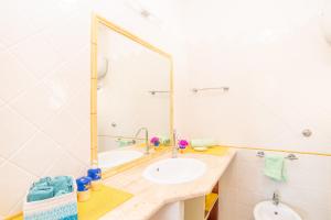 bagno con lavandino e specchio di Flat La Quercia a Palau