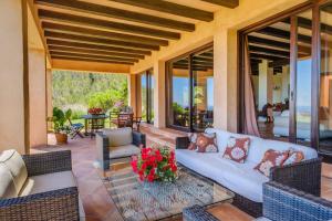 ein Wohnzimmer im Freien mit einem weißen Sofa und Stühlen in der Unterkunft Sa Muntanya panorama in Santa Eulària des Riu