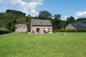 a house with a large grassy field in front of it at Gîte A La Violette in Trois-Ponts