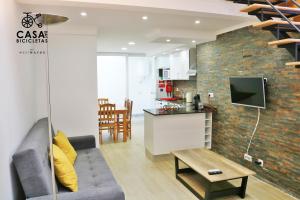 a living room with a couch and a kitchen at Casa das Bicicletas in Peniche