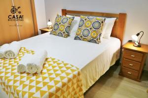 a bedroom with a bed with towels on it at Casa das Bicicletas in Peniche