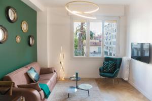 ein Wohnzimmer mit einem Sofa, einem Stuhl und einem Fenster in der Unterkunft Beautiful apartment in the heart of Nice in Nizza
